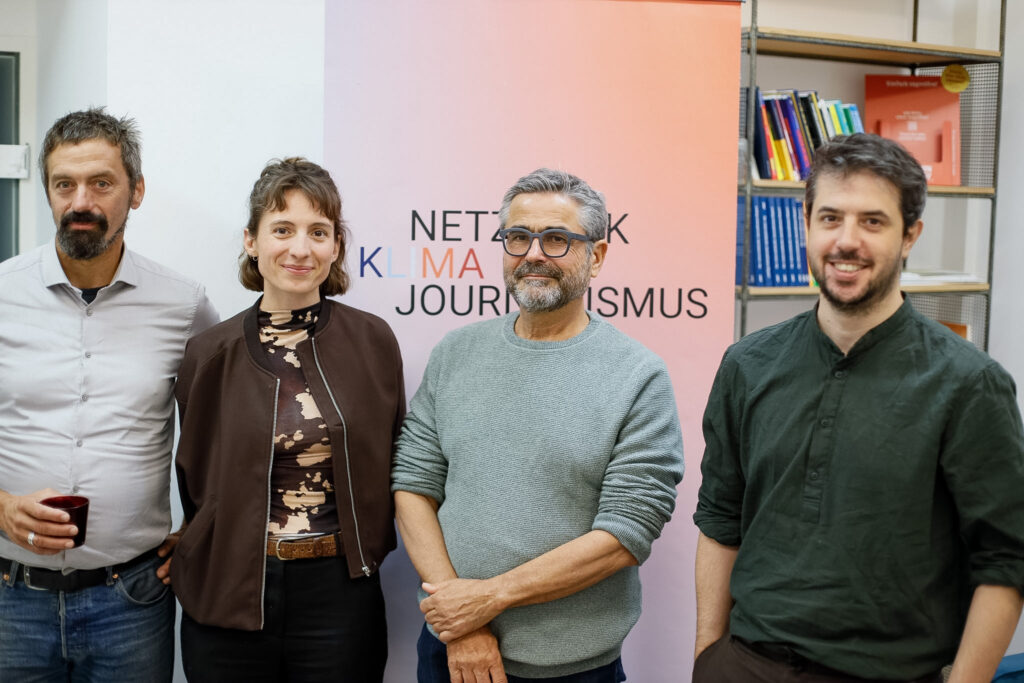 Auf einer Veranstaltung stehen vor einem Roll-Up des Netzwerk Klimajournalismus von links nach rechts Jury-Mitglieder Franz Essl (Biodiversitätsrat Österreich), Katharina Kropshofer (Netzwerk Klimajournalismus Österreich) neben Stifter Norbert Mayr (M2plus) und rechts steht das dritte Jury-Mitglied der Stipendienvergabe Santiago Sàez Moreno (Covering Climate Now)